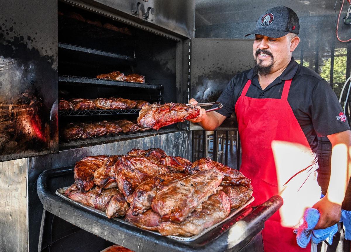 Francisco Sanchez pulls dozens of cuts of tri-tip out of the smoker at Dog House Grill in Fresno. Sanchez says he’ll smoke between 400 and 700 every day. Photographed August 20, 2024.