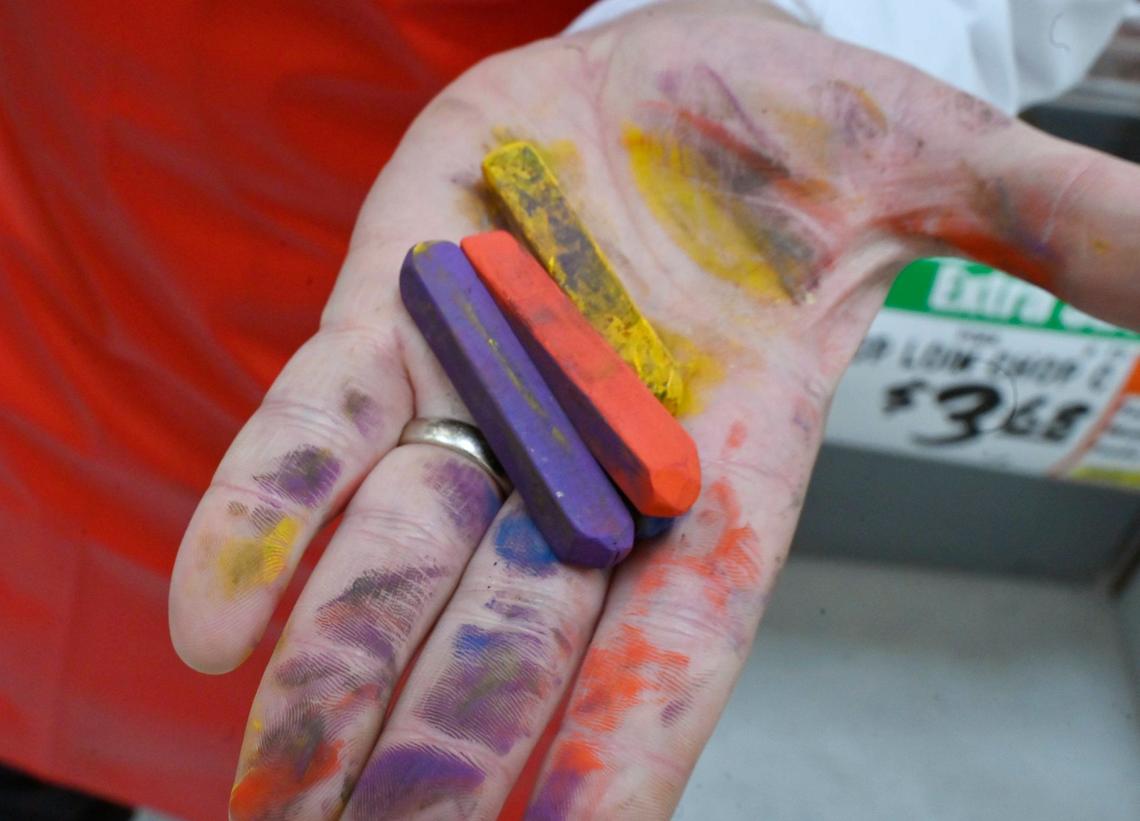 Scott Bolter, better known as Scott In Meat, holds pieces of chalk he has used to create art at WinCo Foods in Clovis where he works in the meat department.