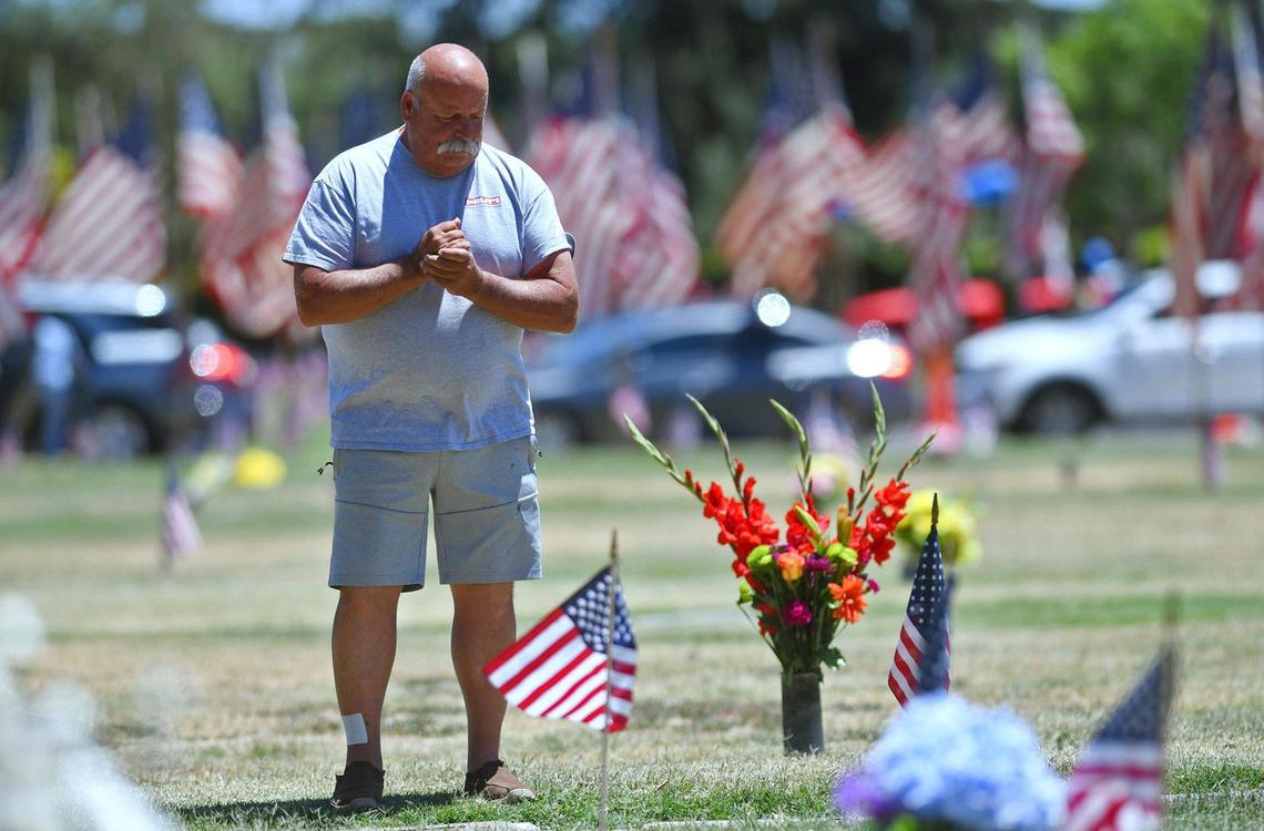 Bruce Calomiris stands at his father Nicholas Calomiris’ grave at Fresno Memorial Gardens Monday, May 30, 2022 in Fresno. Nicholas Calomiris was a WWII veteran who passed away on Memorial Day May 31, 1965.