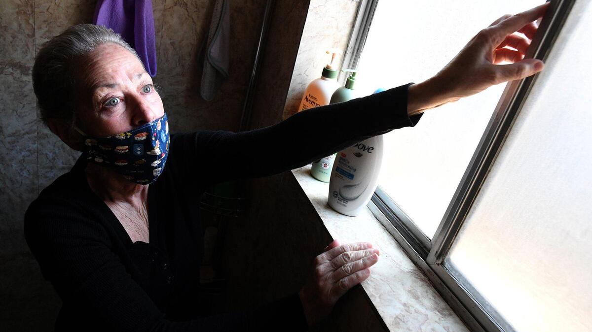 Longtime Manchester Arms Apartments resident and former manager, Laura Denies shows one of the unresolved issues in her apartment on Feb. 17, 2021, a bathroom window that won’t shut all the way. There is mold in the bathroom as well.