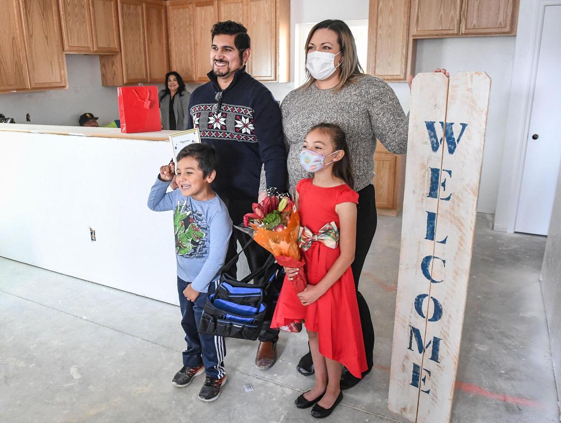 Members of the Delgado family stand in what will be their new home after being announced as the recipients of the newest Habitat for Humanity build in Clovis on Wednesday, Dec. 8, 2021.