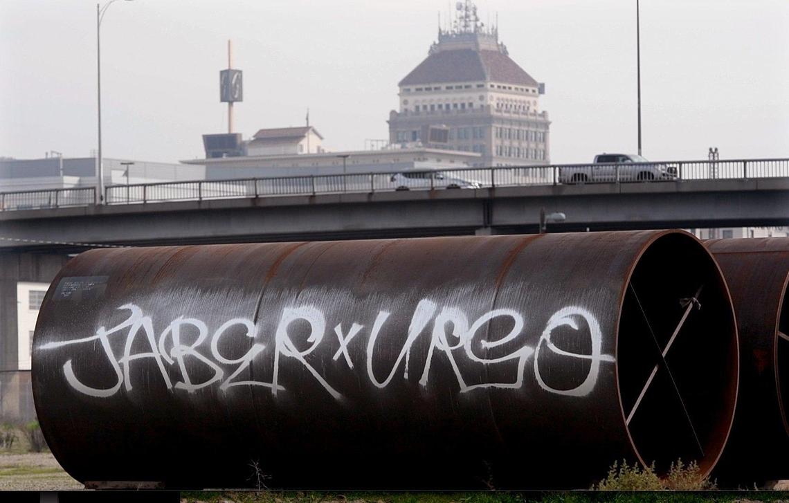 A large construction pipe, hit by graffiti, sits along the HSR project in downtown Fresno, Jan. 13, 2022.