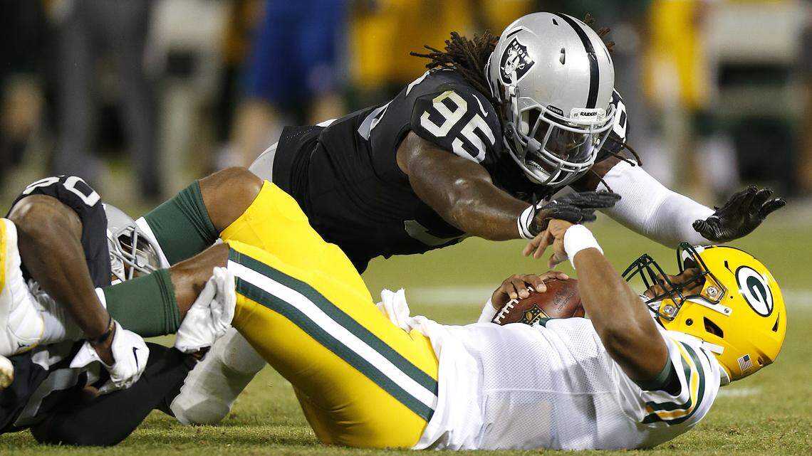 Oakland Raiders defensive end Fadol Brown (95) dives toward Green Bay Packers quarterback DeShone Kizer, bottom right, after Kizer was sacked by Raiders linebacker Nicholas Morrow, left, during the second half of an NFL preseason football game in Oakland, Calif., Friday, Aug. 24, 2018.