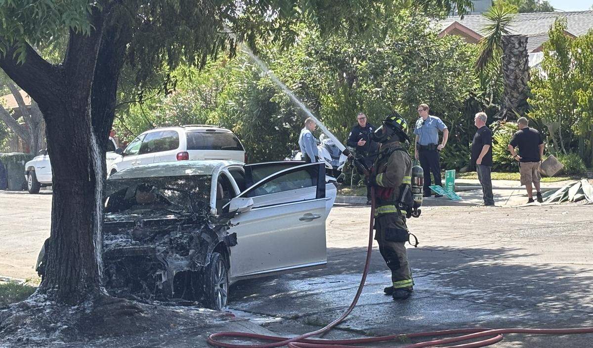Firefighters put out a fire after a car crashed into a tree near Bellaire and Griffith in Fresno on Wednesday, May 20, 2026. The driver fled the scene, police said.