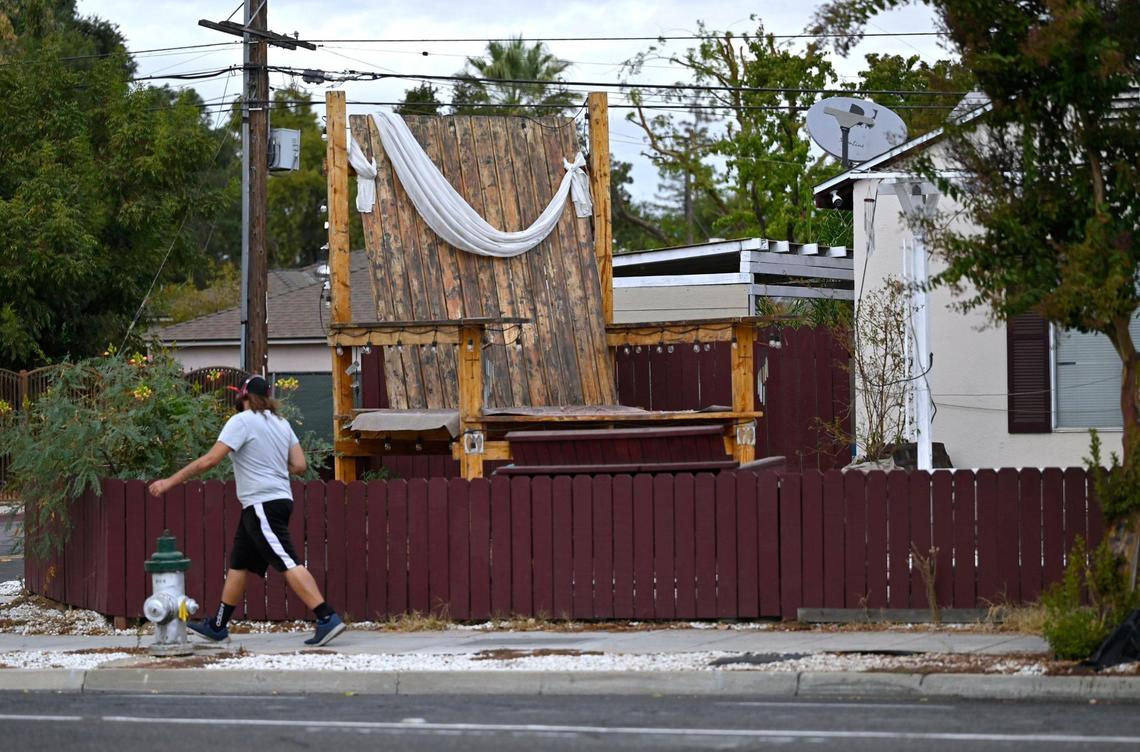 A large wooden chair sits in Robert Sandoval’s front yard along Shields Avenue at Harrison Avenue. Robert said he constructed the chair in 2021 to memorialize his wife Mary Ann who died in a car crash in 2015. Photographed Oct. 16, 2024 in Fresno