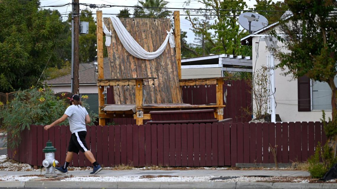 A large wooden chair sits in Robert Sandoval’s front yard along Shields Avenue at Harrison Avenue. Robert said he constructed the chair in 2021 to memorialize his wife Mary Ann who died in a car crash in 2015. Photographed Oct. 16, 2024 in Fresno
