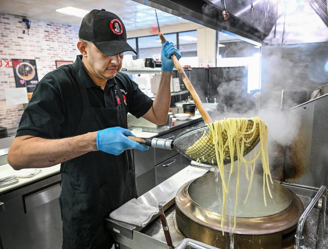 Assistant manager Armando Martinez cooks noodles for an order at Paik’s Noodle in north Fresno on Monday, Jan. 27, 2025