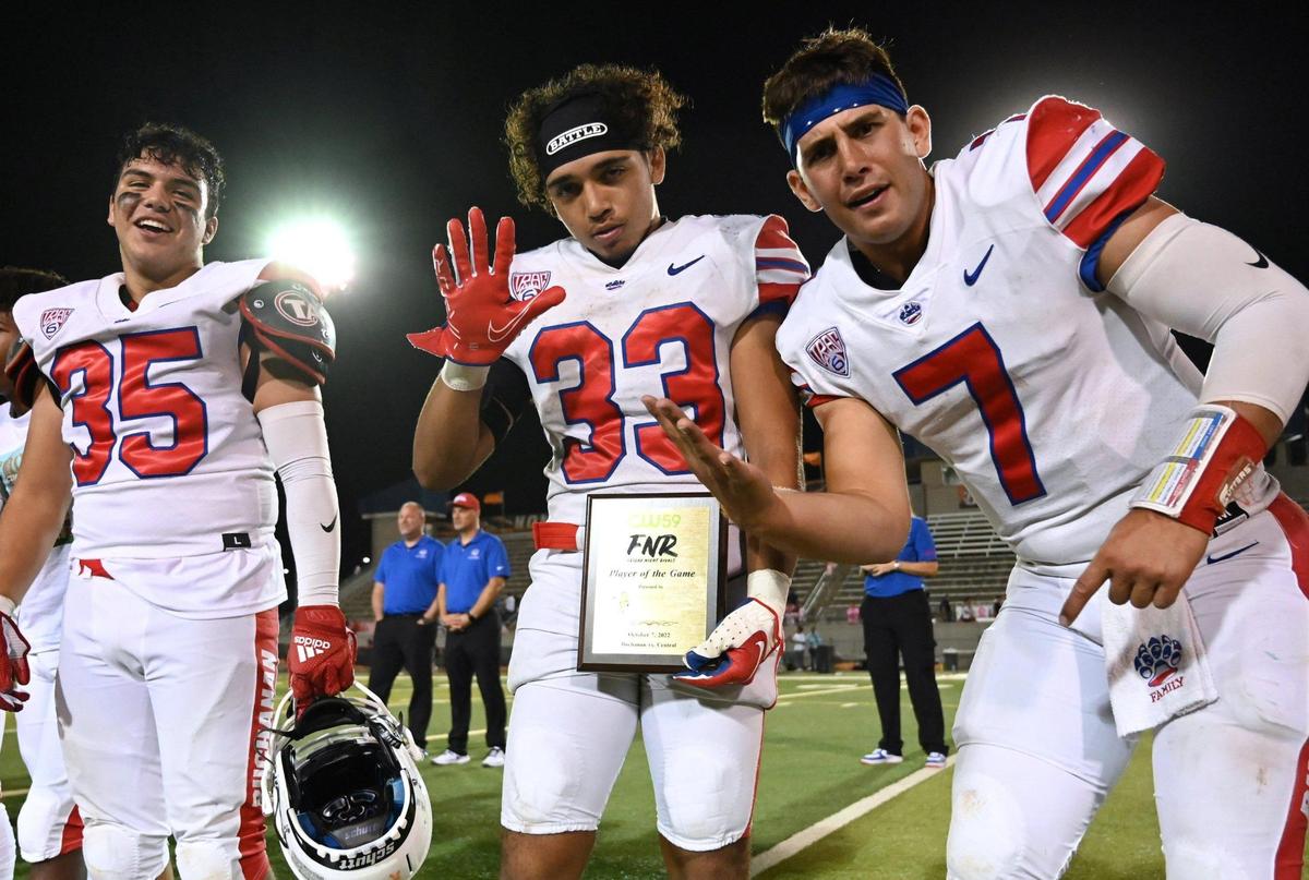 Buchanan’s Michael Runnels, center, holds up his hand to show his five touchdowns scored against Central with quarterback Jayden Mandal, right, and Freddie Gallardo, left, Friday, Oct. 7, 2022 in Fresno. Buchanan won 49-41.