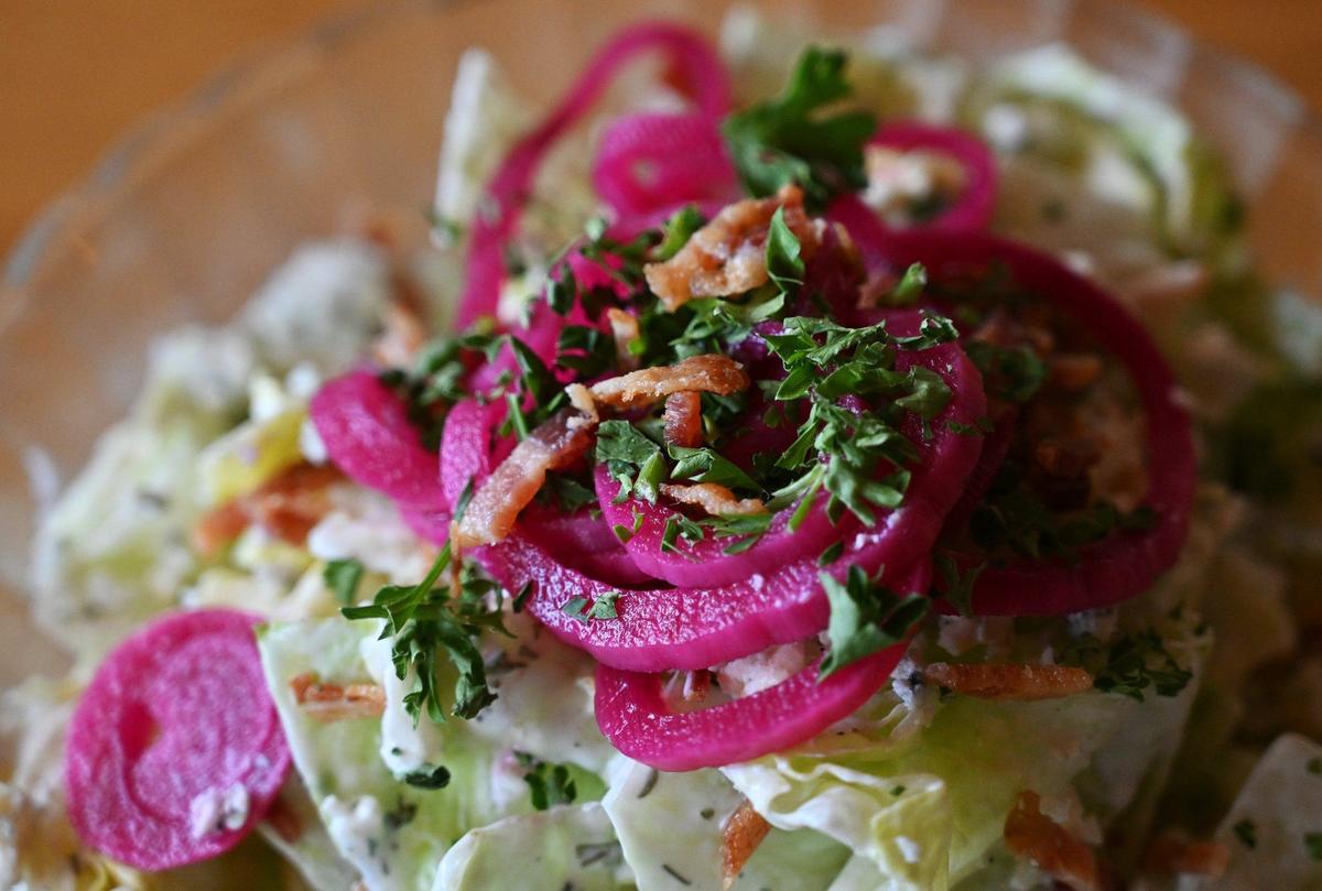 The wedge salad from Smash Bros Bistro is chopped and served in a bowl, featuring pickled beets, blue cheese dressing and bacon.