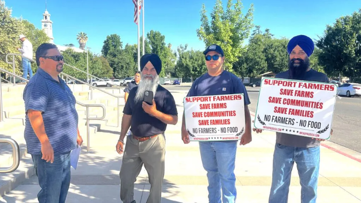 Farmers hold protest signs outside the Madera County Courthouse before a hearing over disputed land assessment fees June 18. A large crowd attended the hearing prompting Judge Brian Enos to note: “This is probably the first time the court has had an absolutely full courtroom with respect to a case like this.”