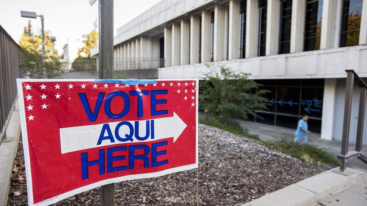 A “Vote Here” sign and tape on windows direct voters to the polls.