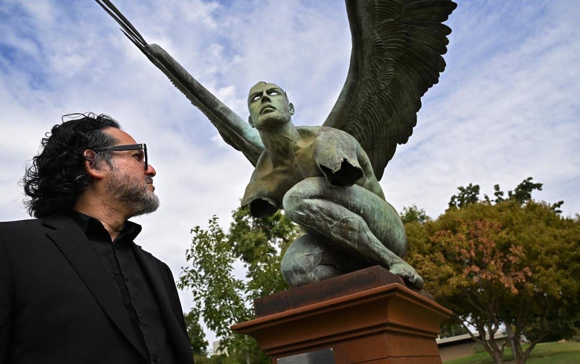 Chris Lopez, director of the Center for Creativity and the Arts at Fresno State stands beside El Tiempo, one of five bronze sculptures, part of the new public art installation titled “Wings of the City” by Mexican artist Jorge Marín. The series is now on display along Fresno State’s Maple Mall which is accessible to the public through 2025.