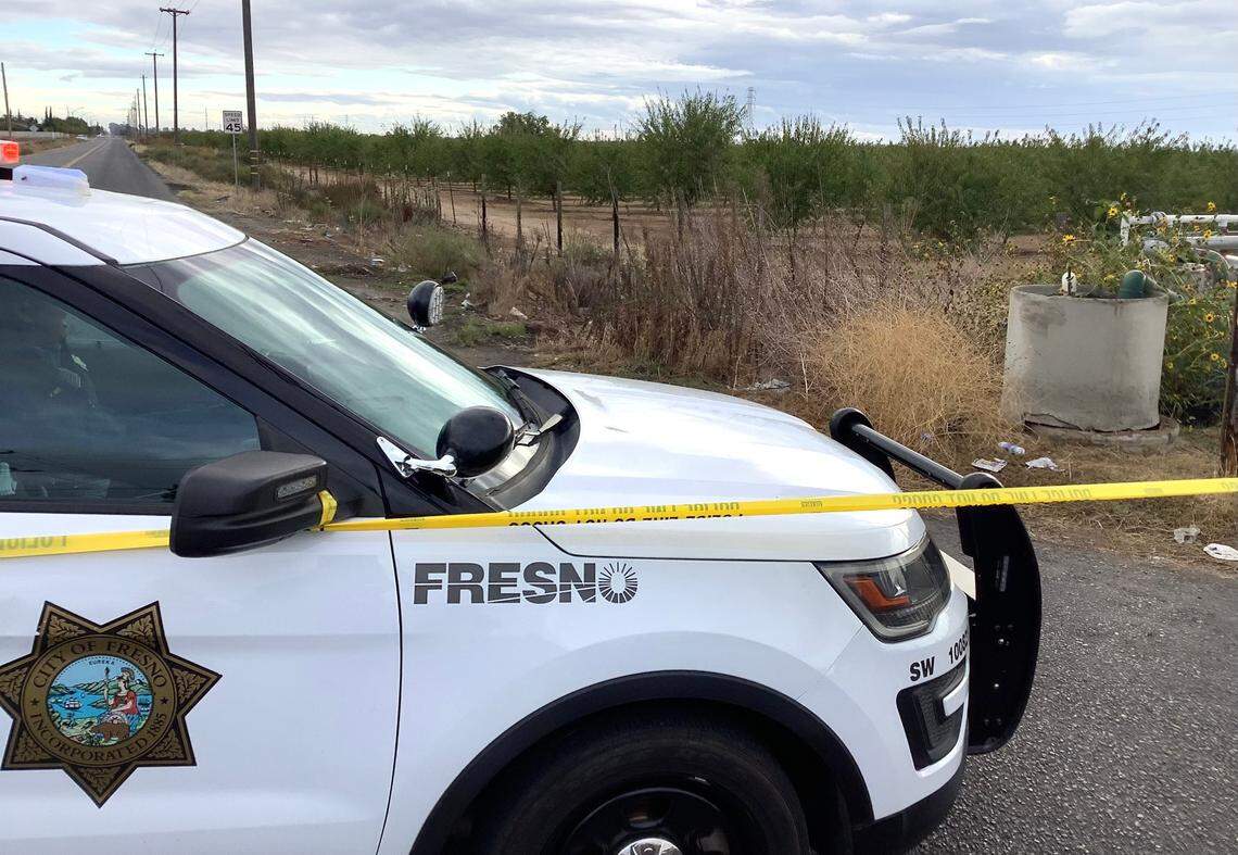 A Fresnp Police patrol vehicle and police tape block access to an almond orchard at Fruit Avenue south of Church Avenue in southwest Fresno on Sunday, Nov. 6, 2022. Investigators searched the orchard and found new physical evidence in the homicide of a young woman and her infant daughter in September.