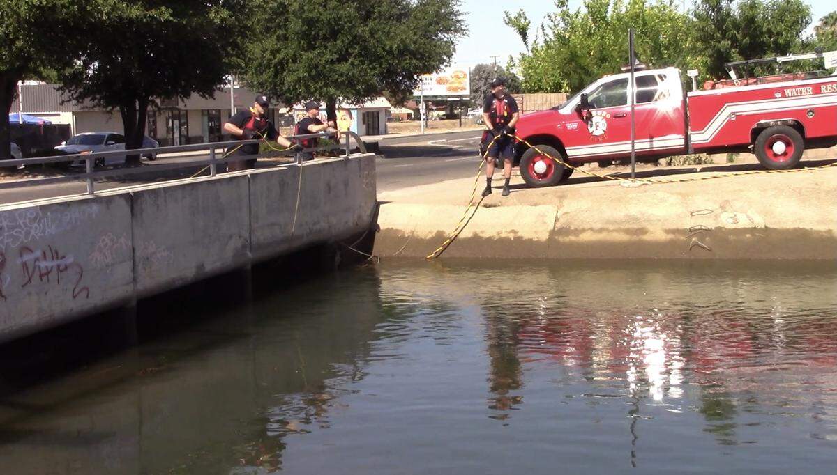 Fresno Fire Department water rescue team team members look for 38-year-old Fresnan Fannie Chindapheth on Friday, June 4, 2021. She fell into the canal and disappeared Wednesday.