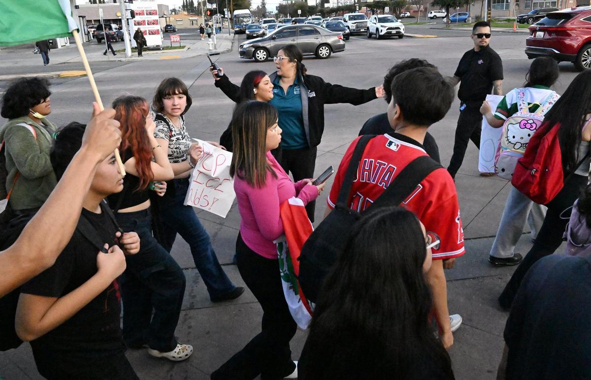 School safety staff, top, direct students from McLane High School across Shields Avenue as they march along Cedar Avenue protesting anti-immigration sentiment in the Federal government Friday, Feb. 7, 2025 in Fresno.