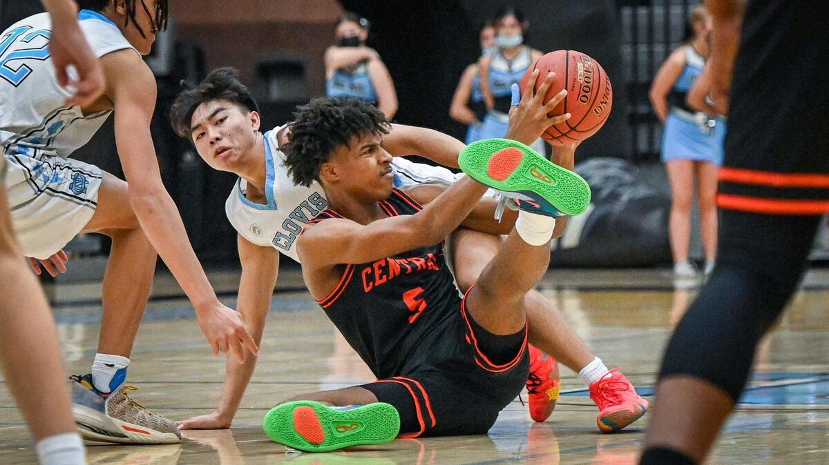 Central’s Marquise Green, center, tries to pass off the ball after colliding with Clovis North’s Shawn Wong, left, during their game at Clovis North on Friday, Jan. 21, 2022. Green scored 19 points in the Central Section Division I championship game on Thursday, Feb. 24, 2022.