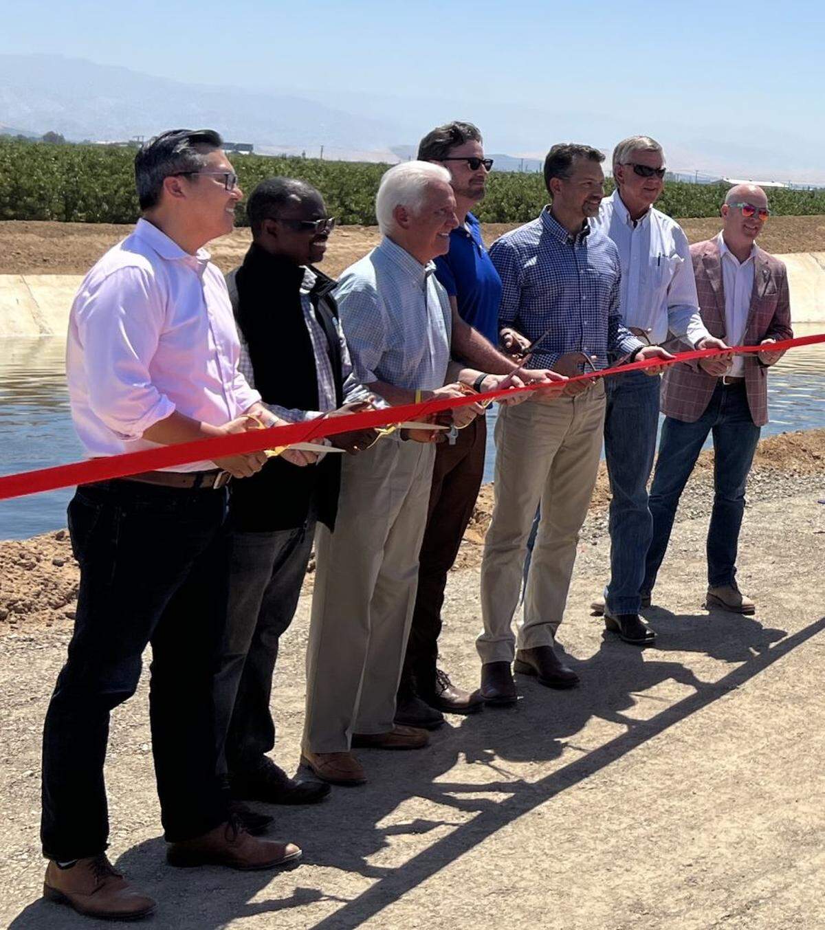 Friant Water Authority CEO Jason Phillips, third from right, at a ribbon cutting ceremony marking completion of the first phase of construction to fix the Friant-Kern Canal.