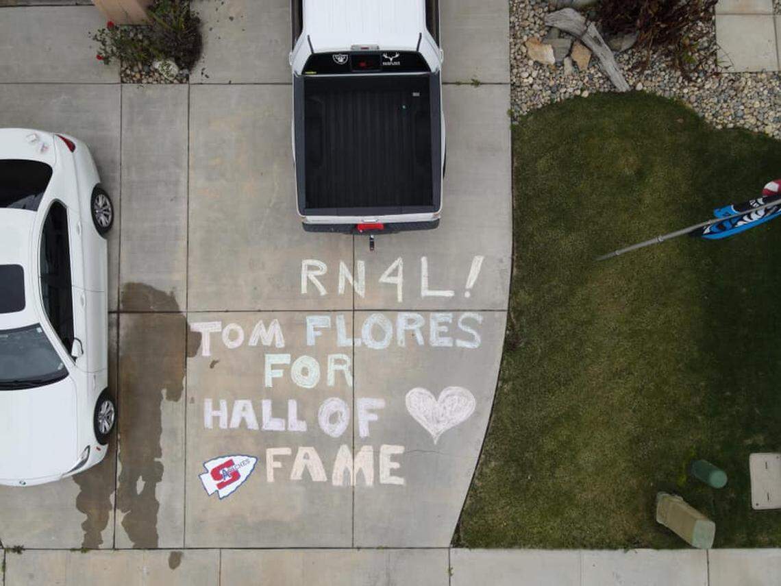 John Karmann shows his support for former Sanger High star Tom Flores by chalking it up on his driveway in Sanger, California.