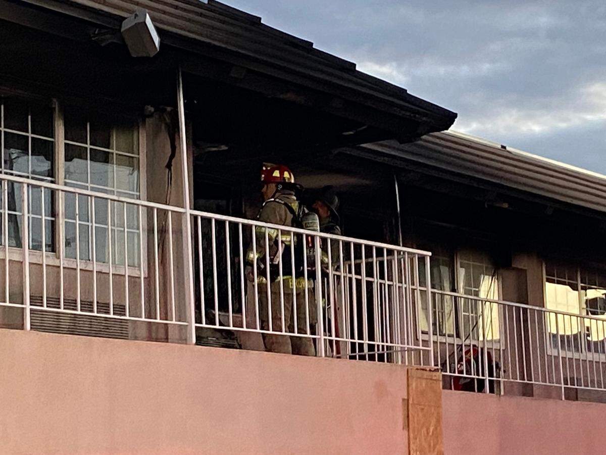 Firefighters survey the damage after a blaze at the former Days Inn in Fresno, California, on Tuesday, March 15, 2022.