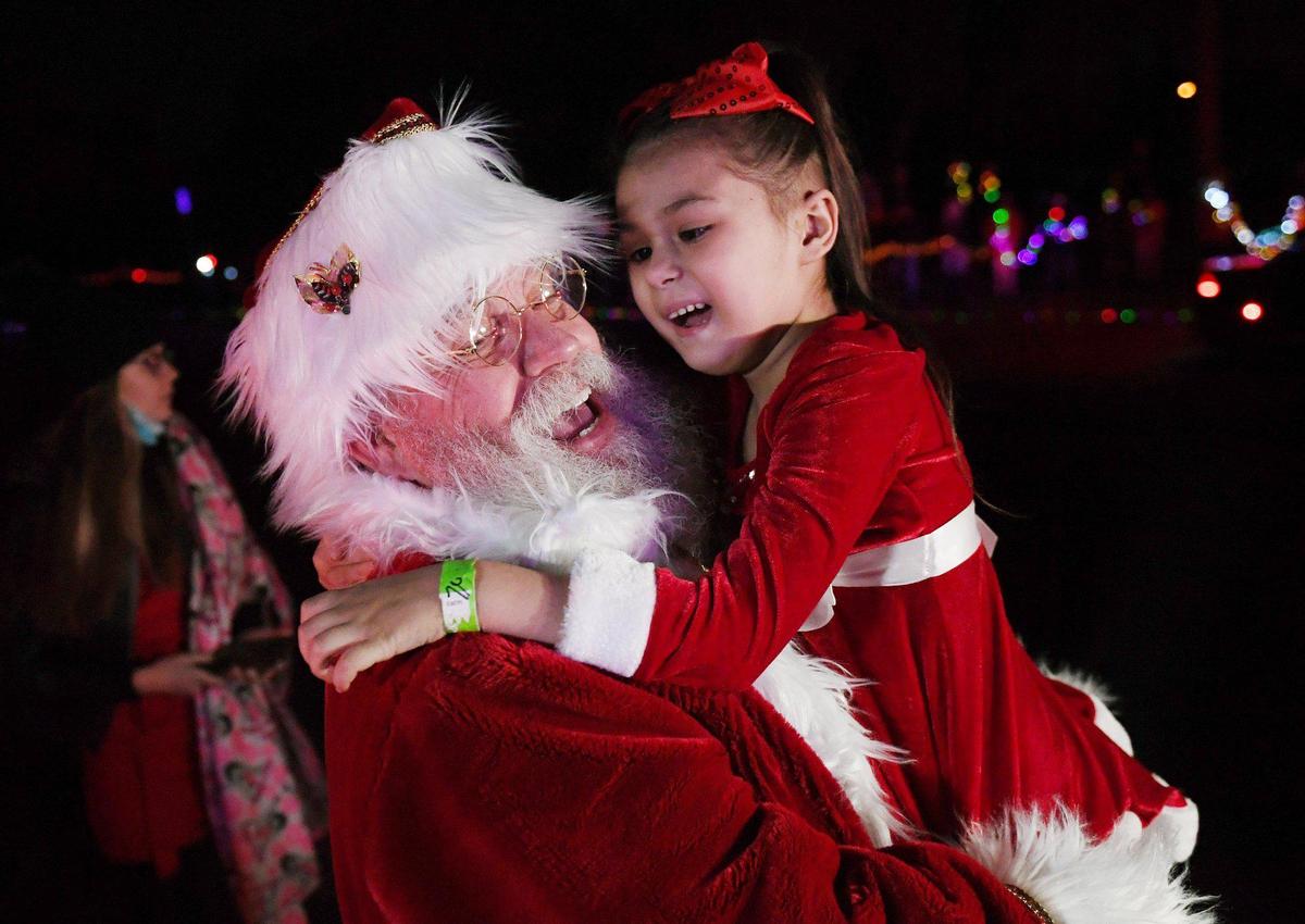 Arianna Jasso, age 6, laughs as she experiences a special surprise early Christmas, possibly her last, held by Santa at Woodward Park Saturday night, Nov. 21, 2020 in Fresno. Arianna was diagnosed July 20 with a brain tumor called diffuse intrinsic pontine glioma (DIPG) which carries a life expectancy post-diagnoses of six to nine months.