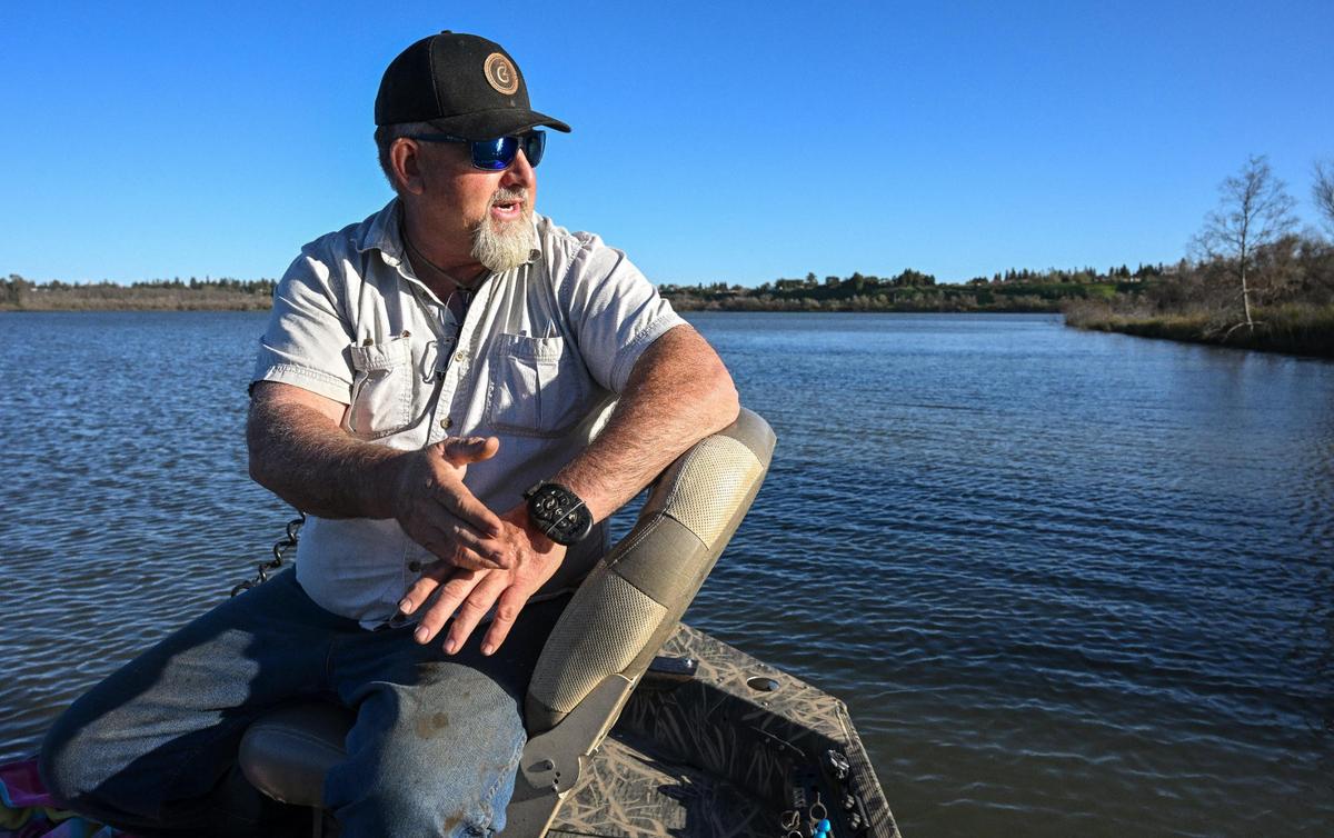 El guía de pesca Louis Moosios mira hacia Milburn Pond mientras habla de los posibles cambios que podrían afectar al ecosistema del estanque al norte de Fresno, el jueves 14 de marzo de 2024.