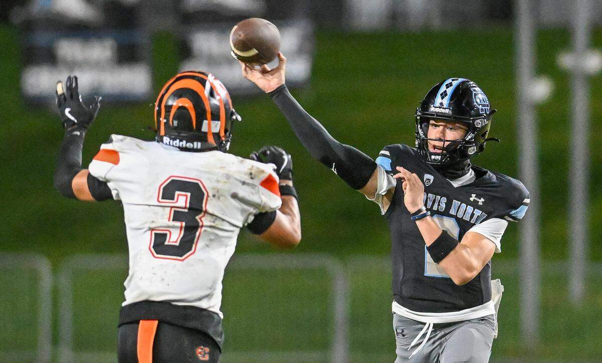 Clovis North quarterback Lucas Smith throws while getting pressure from Central East's Andrew Garcia during their TRAC opener at Veterans Memorial Stadium in Clovis on Thursday, October. 2, 2025.