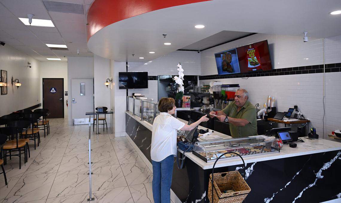 Sanjay Gadh, right, handles an order from a customer at Focaccia which was opened with his wife Renu Arora almost 6 months ago, serving cold, hot and panni sandwiches and salads. Photographed Thursday, Sept. 18, 2025 in Fresno.
