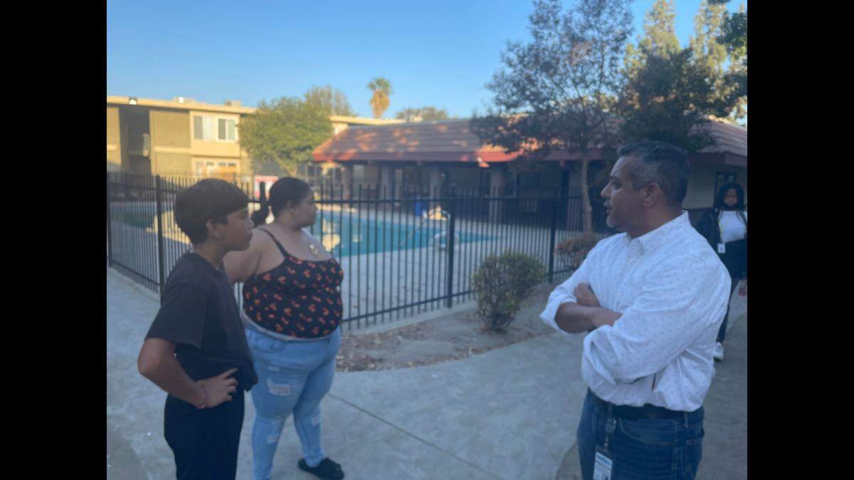 Fresno City Councilman Miguel Arias, right, speaks with Phillip Alejandrez and Ashley Gadison at The Reserved Apartment Homes near First and Tulare streets.