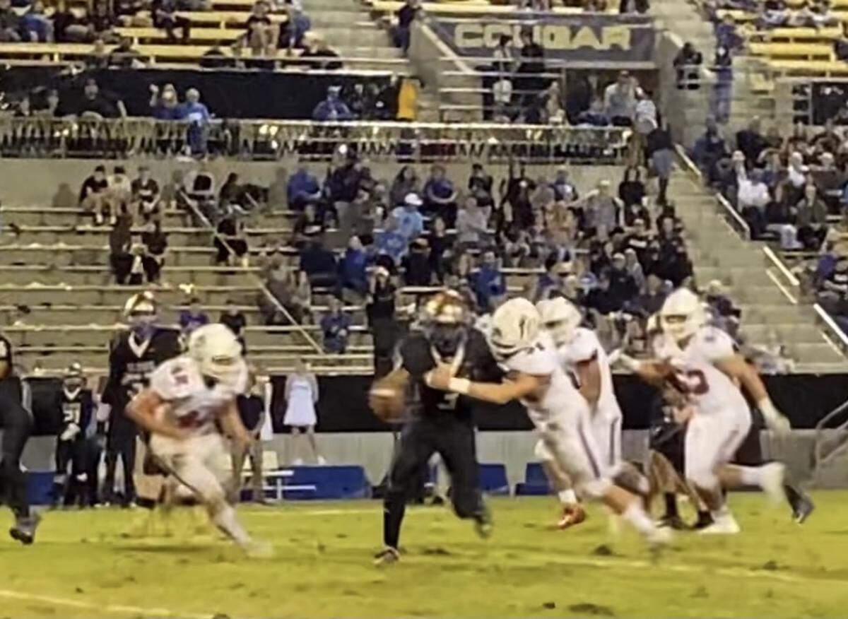Clovis High quarterback Nate Johnson is chased by Buchanan defenders at Lamonica Stadium on Friday, Oct. 15, 2021.