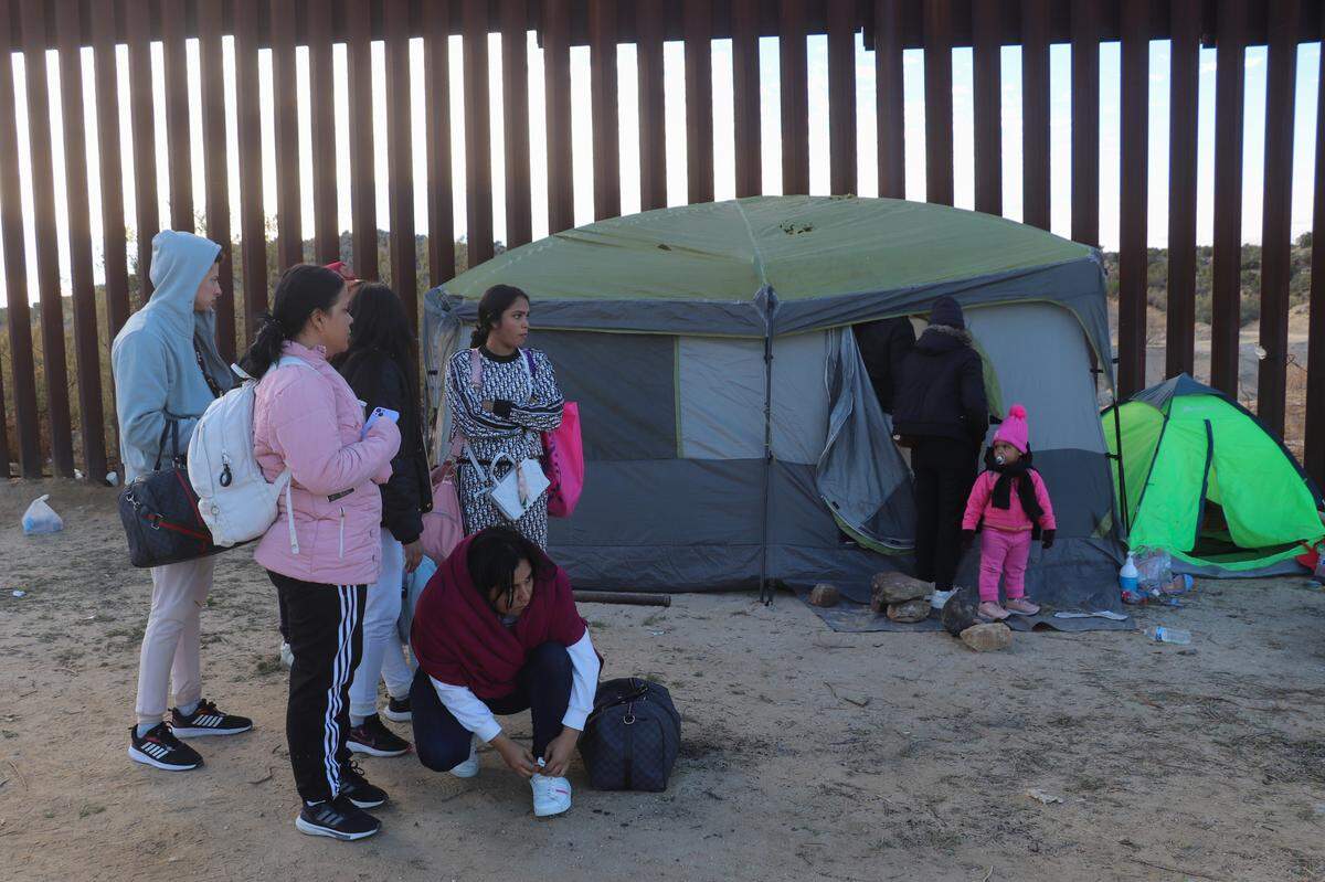 Un grupo de migrantes espera su turno para pasar a Estados Unidos el 29 de noviembre en la zona del puesto fronterizo de Jacumba, a unas 75 millas (120 kilómetros) al este de San Diego, California.