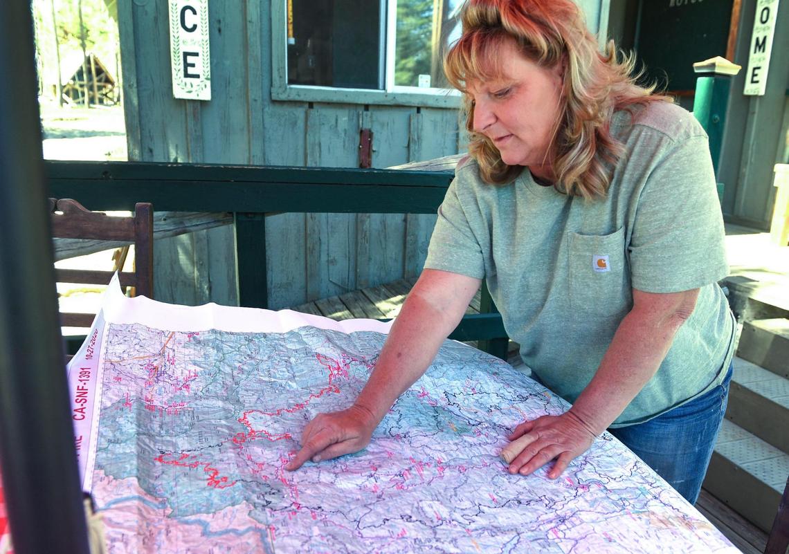 Mikki Terzian looks over a map showing how close the Creek Fire came to the Minarets Pack Station, as she gets ready for the first guided rides at the station since the fire, on Friday, June 11, 2021.