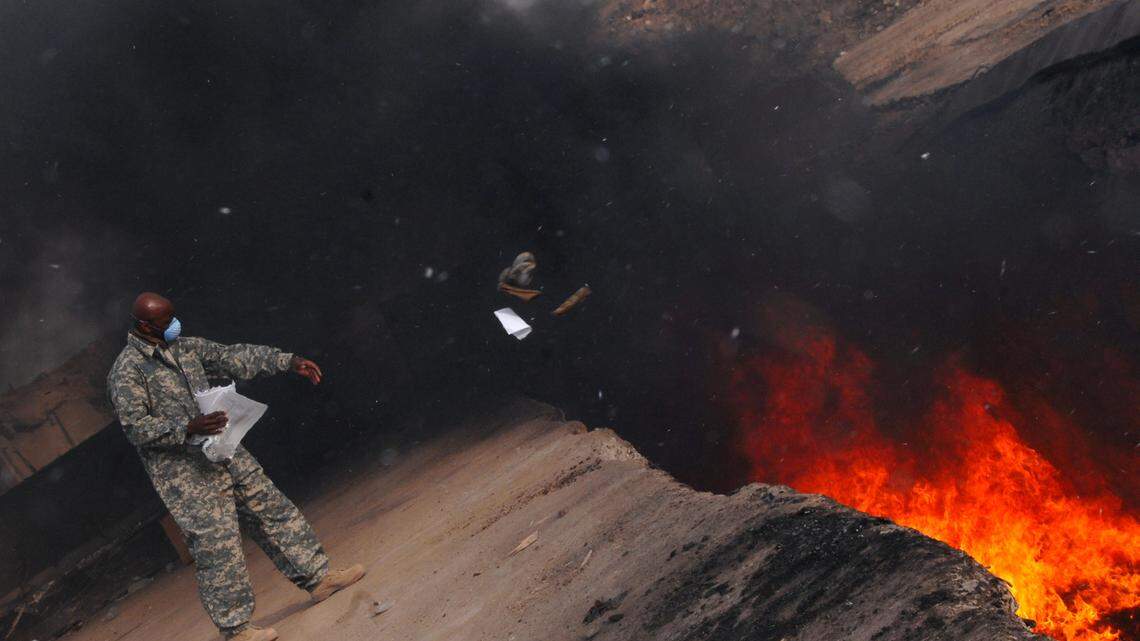 U.S. Air Force Master Sgt. Darryl Sterling tosses unserviceable uniform items into a burn pit at Balad Air Base, Iraq, on March 10, 2008. Hundreds of veterans and their families went to federal court trying to prove that burn pits such as this one made U.S. troops sick.