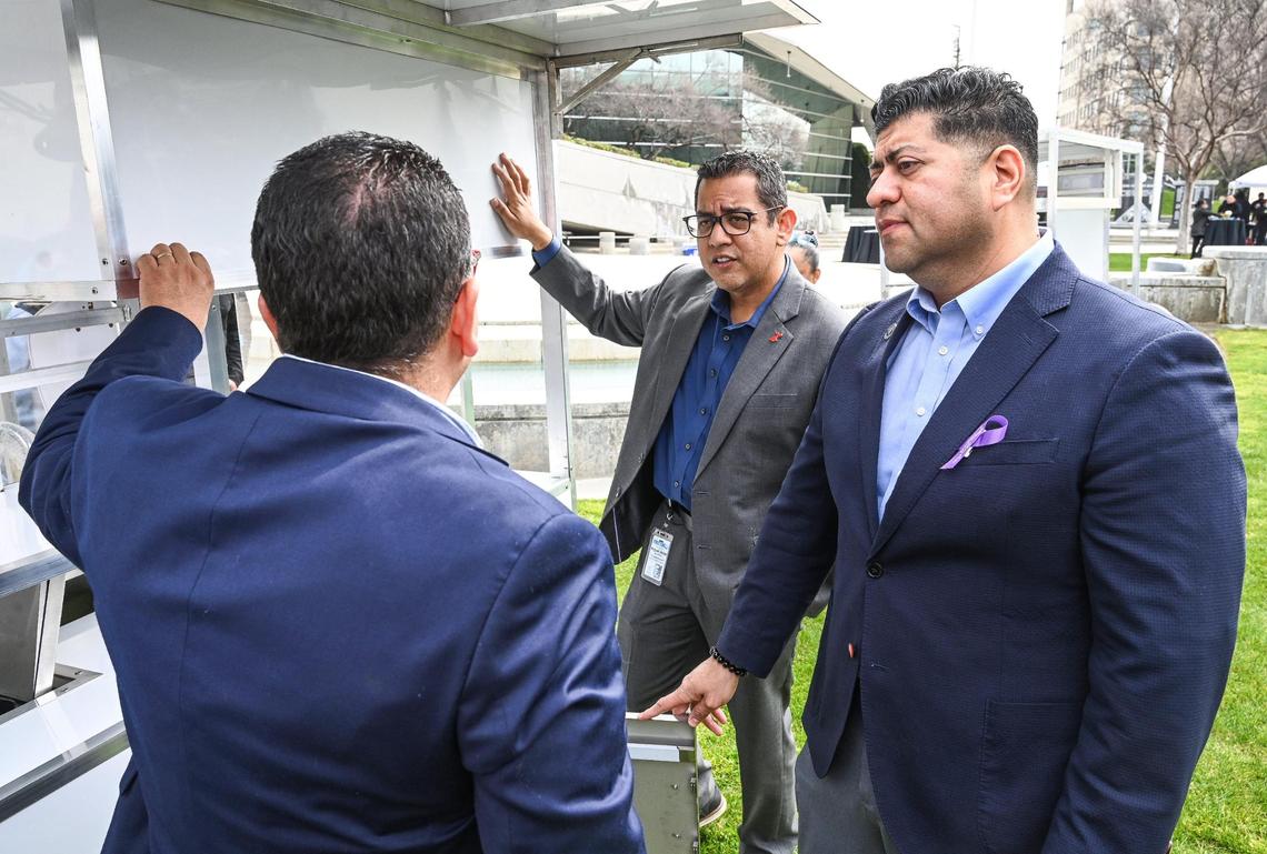 Fresno City council members Miguel Arias, center, and Luis Chavez get information about a new food cart prototype that meets permitting standards from the Fresno County Health Department during an unveiling event at Fresno City Hall on Thursday, March 9, 2023.