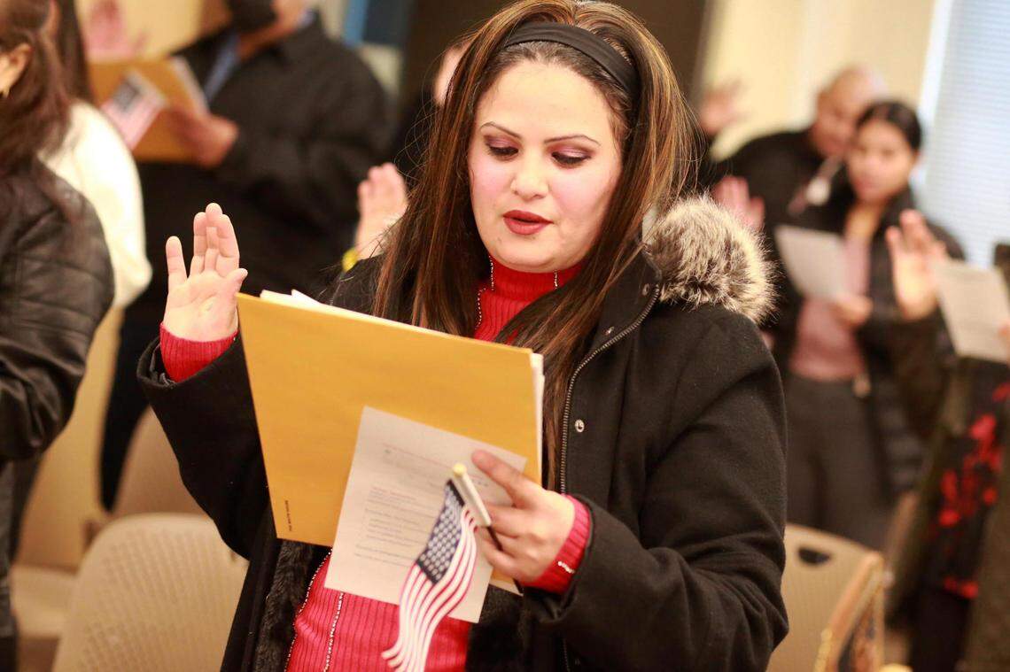 Nuevos ciudadanos americanos toman juramento a la bandera de los Estados Unidos durante una ceremonia de naturalización el martes, 24 de enero en las oficinas del Servicios de Inmigración y Ciudadanía de los Estados Unidos en Fresno.