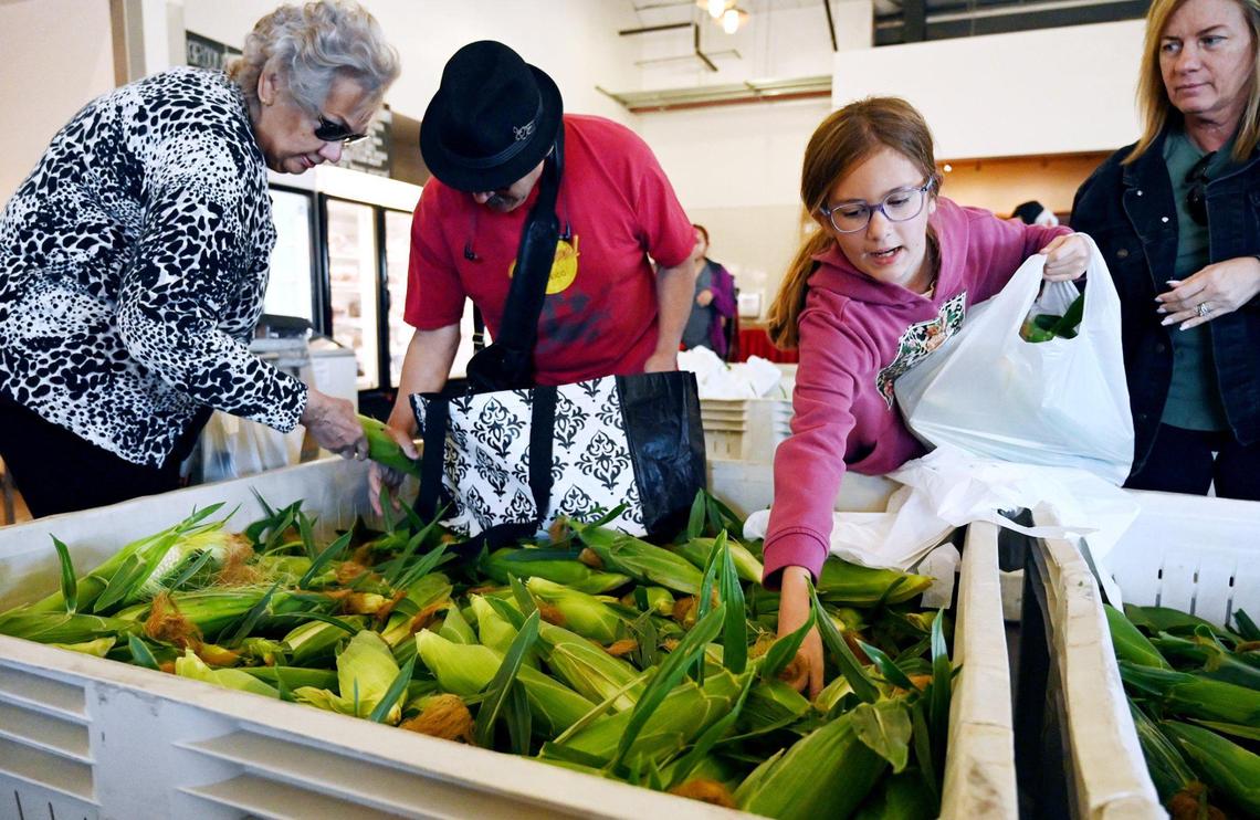 Charlet Bron, 11, right, reaches for corn on the first day Rue and Gwen Gibson Farm Market began selling the popular seasonal sweet yellow and white corn ears to the public. Photographed Monday, May 30, 2022 in Fresno.