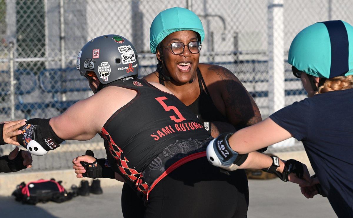 Jessica “Afrodisiac” Meredith, center, laughs as she tries to break through blockers during the Ash City Roller Derby practice at Cary Park on Thursday, May 6, 2025, in Fresno, California.