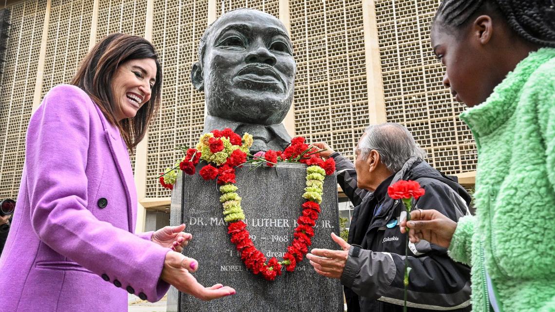 Fresno County Superintendent of Schools Dr. Michele Cantwell-Cophers, left, and Dr. Sudarshan Kapoor, center, help students place flowers on the MLK memorial bust during the annual Martin Luther King garlanding event at Fresno County Courthouse Park in Fresno on Friday, Jan. 13, 2023.The 39th annual events were kicked off with the garlanding ceremony at the MLK memorial bust to honor and remember slain civil rights leader Rev. Dr. Martin Luther King Jr.