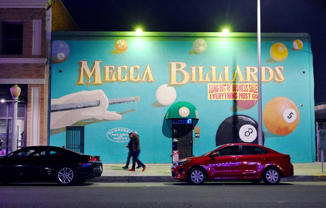 Mecca Billiards is seen at night on Fulton Street in downtown Fresno’s Brewery District, Friday, Feb. 10, 2023. Nanette Stockle, who operated Mecca Billiards with her husband until his death of ALS in February, is selling everything from the store in preparation to lease the building. The mural will remain.