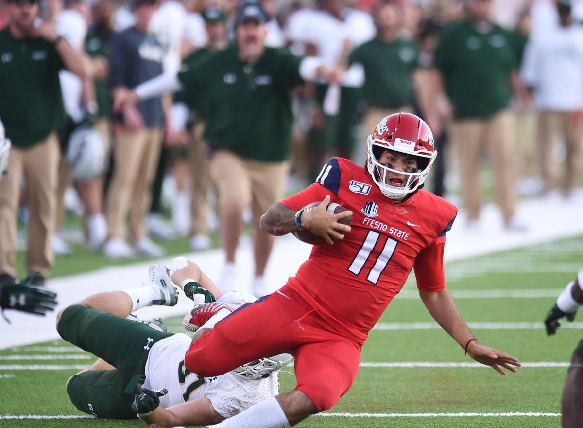 Fresno State quarterback Jorge Reyna, center, slides to the ground pursued by Colorado State’s Jan-Phillip Bombek, background, Saturday, Oct. 26, 2019 in Fresno.