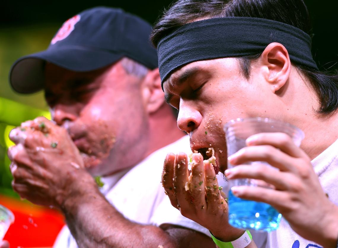 Geoffrey Esper, left, and Matt Stonie wolf down carrne asada tacos at the Taco Truck Throwdown 8 taco-eating contest Friday night, July 20, 2018 in Fresno. First place Esper beat out Stonie with a total of 73 tacos within 8 minutes. Stonie placed second with 65.