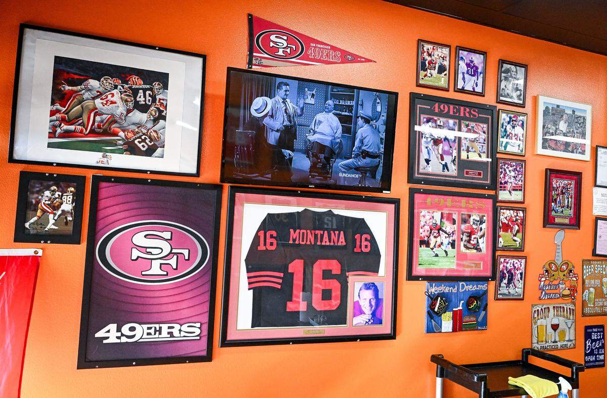 San Francisco 49er photos and memorabilia cover a wall at Weekend Dreams Burgers & Grill in west Fresno where the owners are huge sports fans.