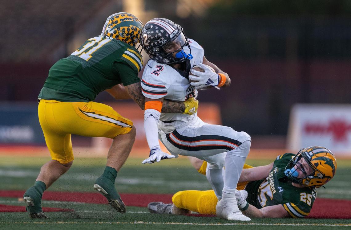 The Central Grizzlies’ Brandon Smith (2) is stopped after a first down by the Edison Chargers’ Matt Lopez (31) and Carson Schmidt (25) during the CIF State Division 1-A championship at Saddleback College in Mission Viejo on Saturday.
