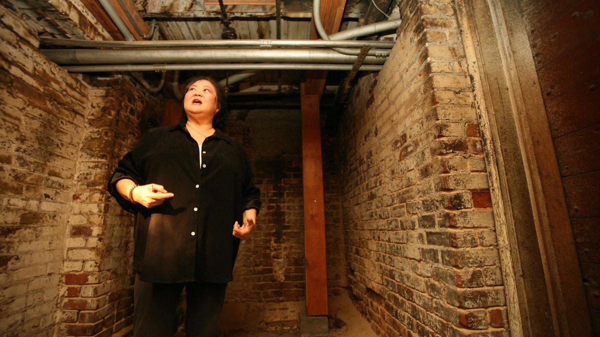 Kathy Omachi, de la organización sin ánimo de lucro Chinatown Revitalization Inc., camina por un sótano interconectado bajo una cuadra de Chinatown en esta foto de archivo de 2007. Las visitas a los sótanos y túneles bajo Chinatown se reanudarán a principios de 2024.
