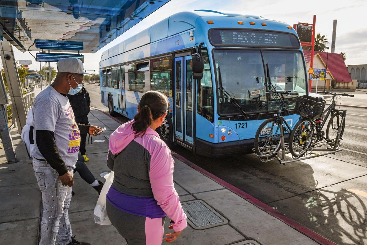 Passengers prepare to board a FAX bus at a stop near Manchester Center in Fresno on Wednesday, Oct. 20, 2021.