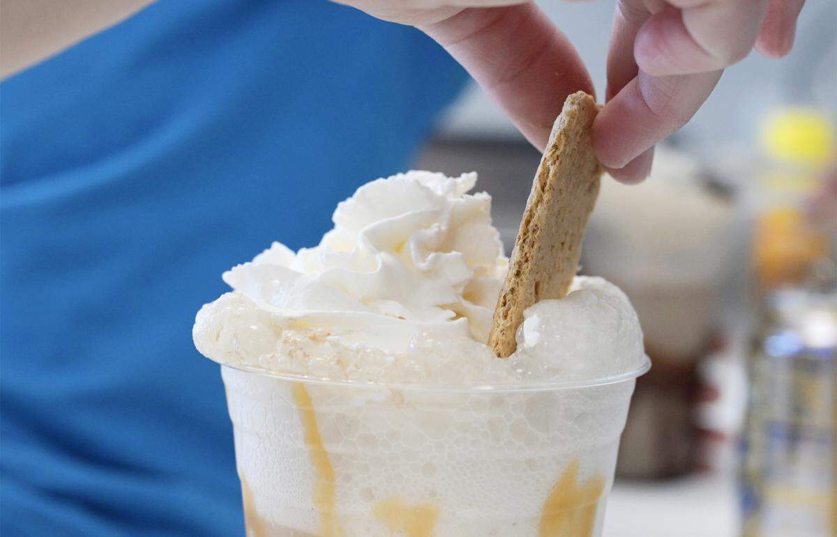 Janel Haas places a graham cracker as a finishing touch in a Caramel Apple in a Cup Fizzy Float at Jay’s Specialty Ice Cream which has just opened along Shaw Ave. west of 99. The shop will host its grand opening Saturday, Sept. 27, 2025. Photographed Monday, Sept. 22, 2025 in Fresno.