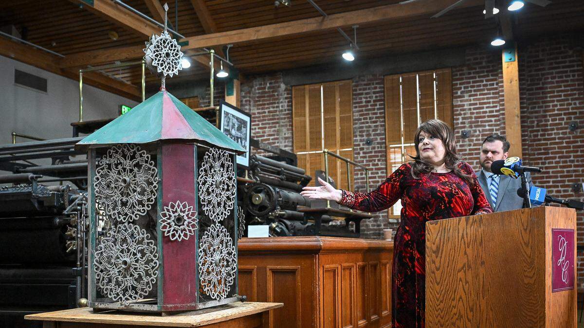 Elizabeth Laval, president of the Fresno City & County Historical Society, stands next to one of 82 lanterns while discussing the mystery of the lanterns found earlier this year by CalTrans workers building the California High-Speed Rail project through Fresno, during a press conference at The Archive on Kern on Friday, Dec. 19, 2025.