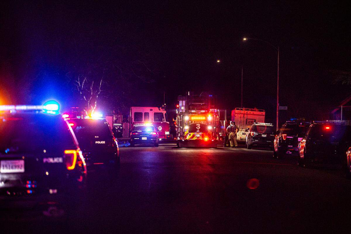 Police close down street after two men were killed and two others were wounded in a shooting that happened at an apartment complex in southwest Fresno, on Sunday, Feb. 6, 2022.