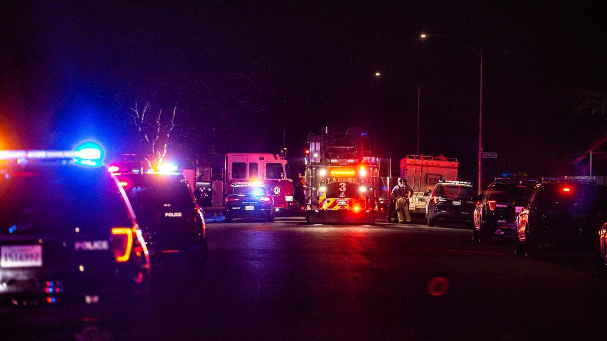 Police close down street after two men were killed and two others were wounded in a shooting that happened at an apartment complex in southwest Fresno, on Sunday, Feb. 6, 2022.
