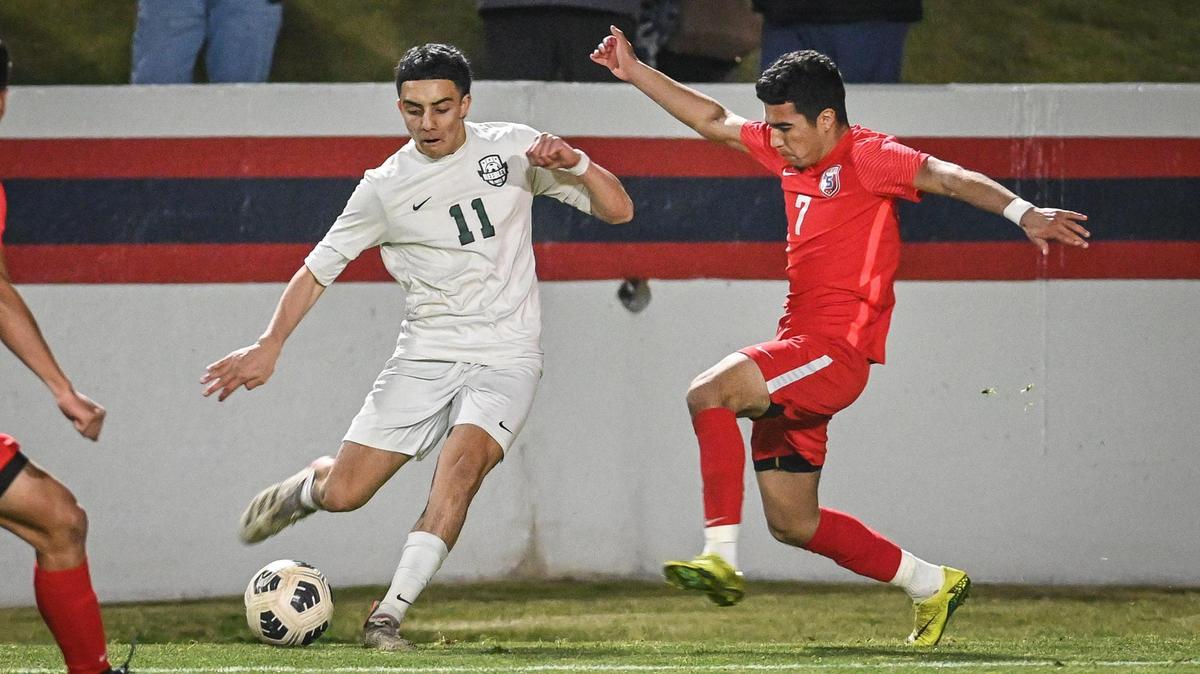Reedley’s Levy Alcantar, left, kicks the ball toward the goal while defended by Sanger’s Luis Martinez during their Central Section Division I soccer championship game at Sanger’s Tom Flores Stadium on Friday, Feb. 25, 2022.