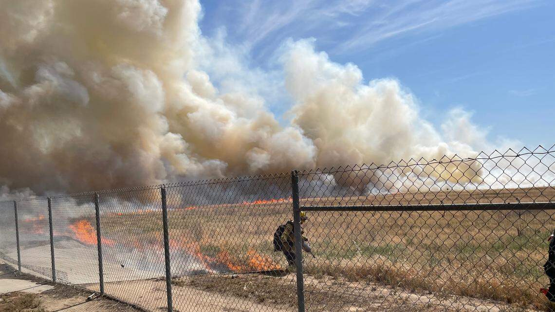 Cal Fire firefighters battle a grass fire in a dry ponding basin just north of Clovis on Thursday afternoon, May 6, 2021.